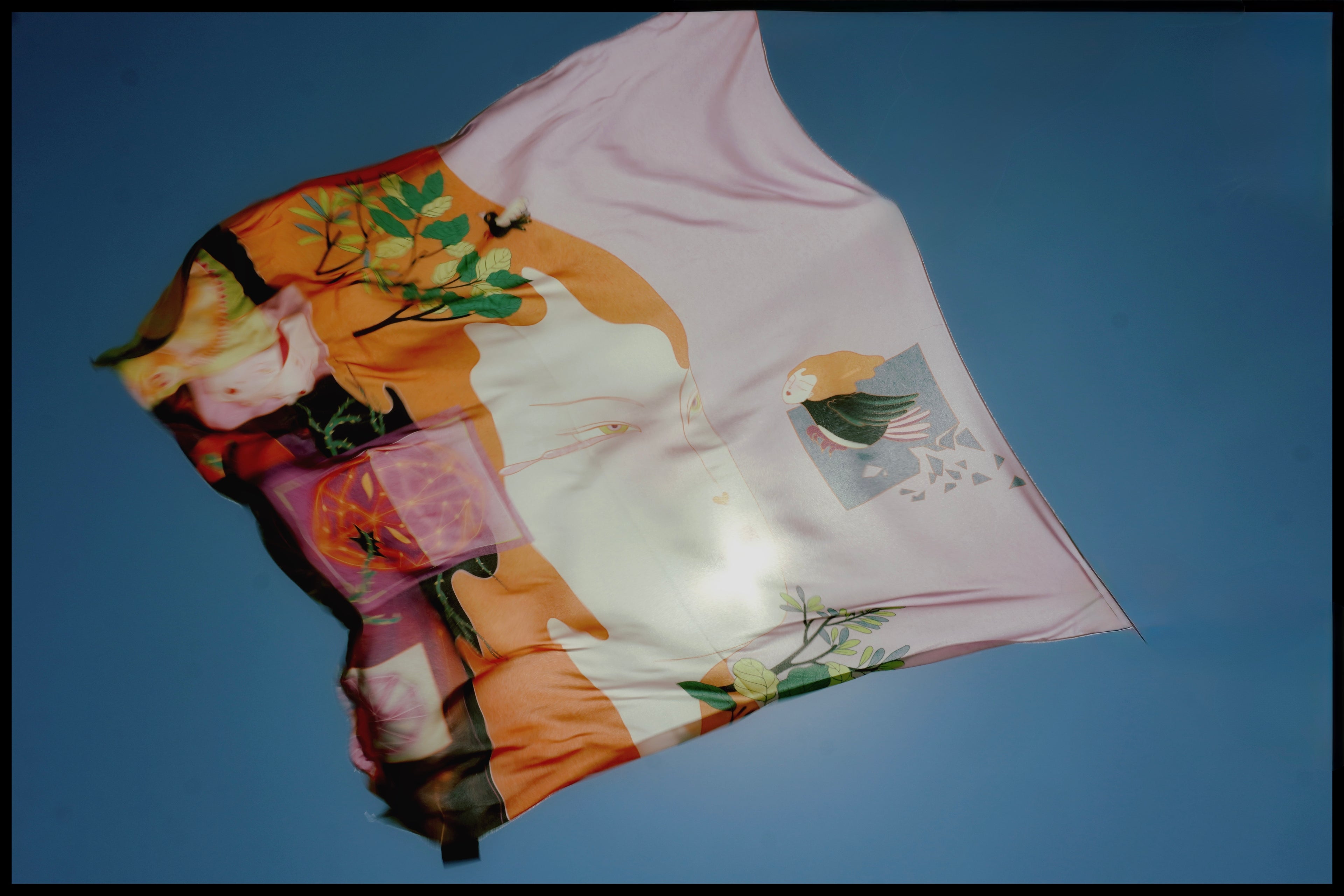 Printed scarf by Leah Han showing blurred conceptual illustration against a clear blue sky
