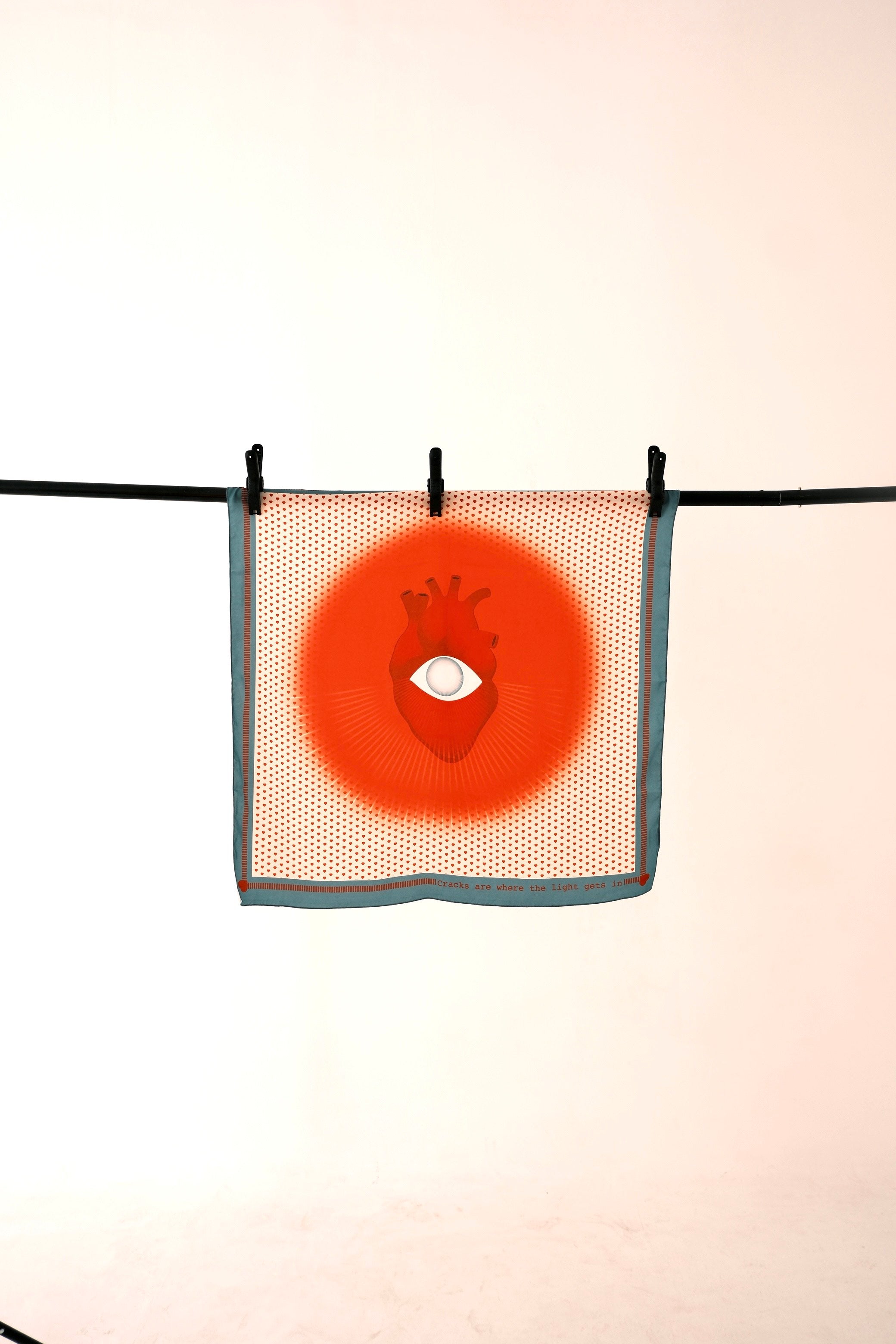 Heart of Light orange art silk scarf hanging on a rod – full view