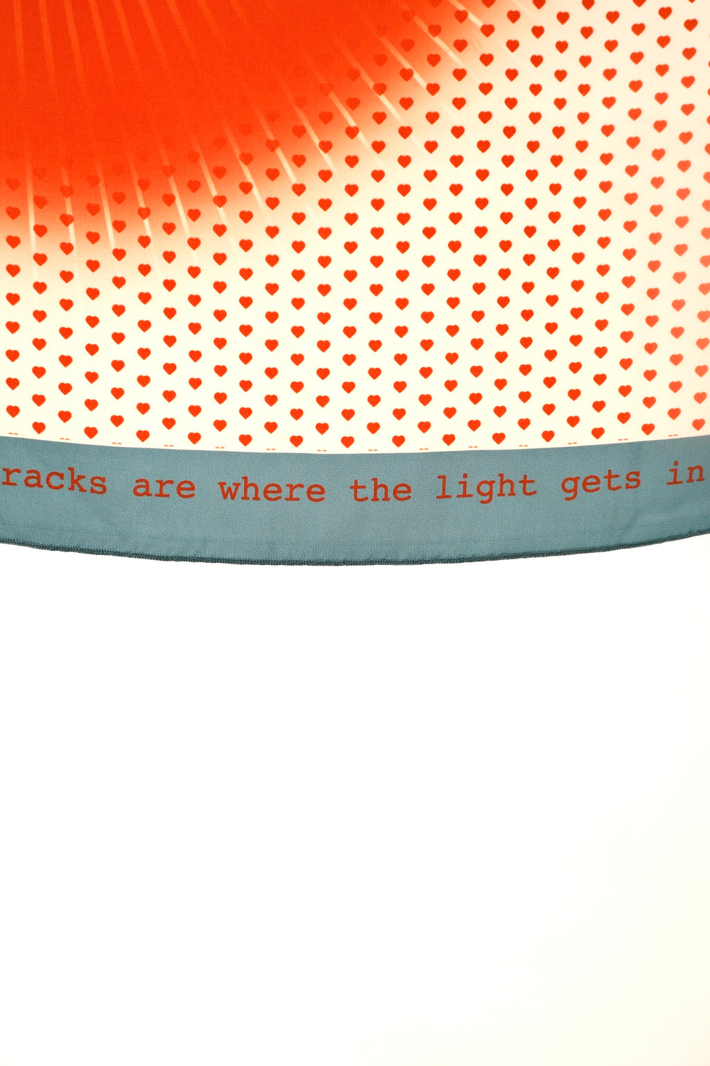 Scarf from DAE with heart pattern and text 'tricks are where the light gets in' on a white background