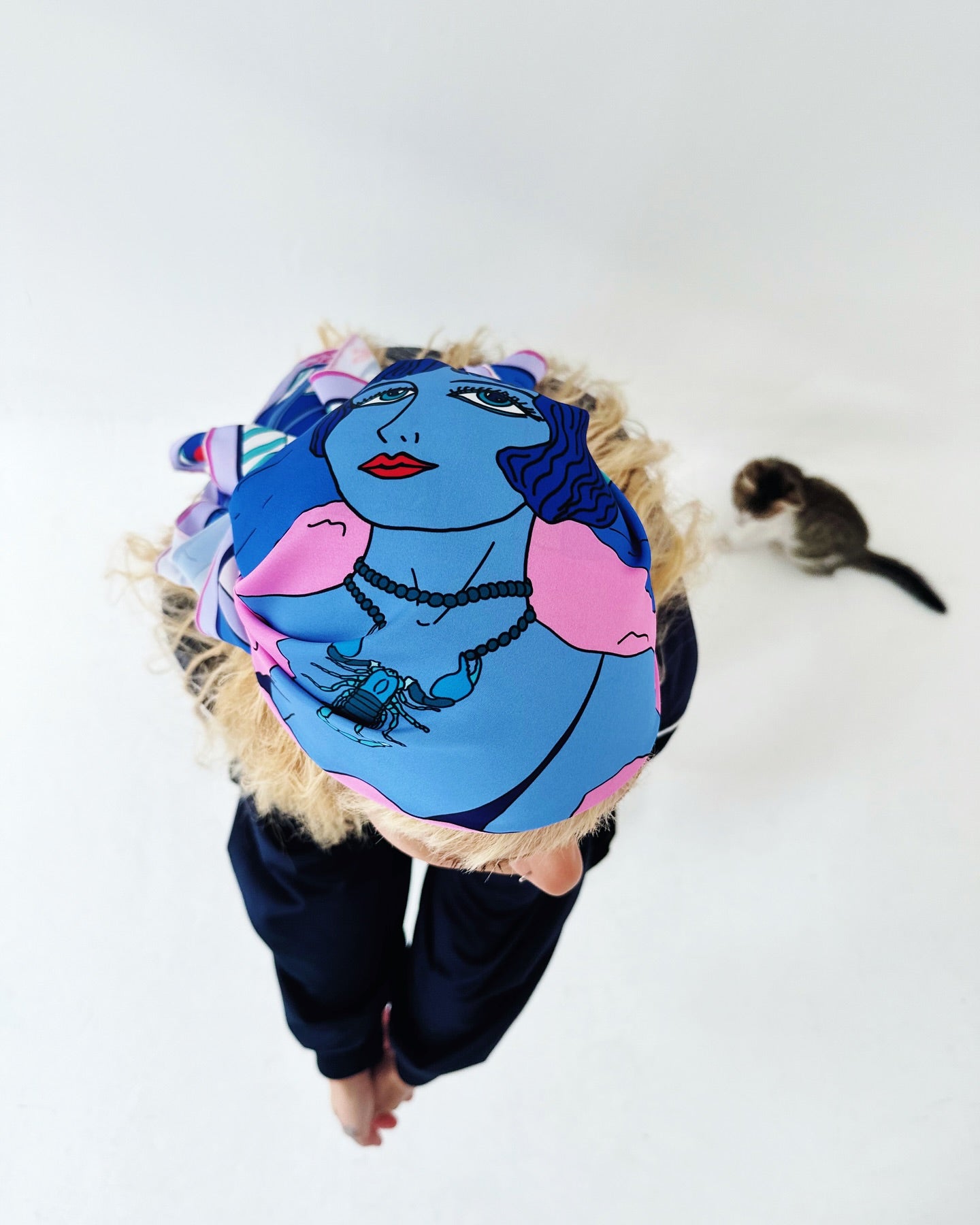 Scorpio zodiac silk scarf in vibrant purple, blue, and pink tones displayed on soft white fur background