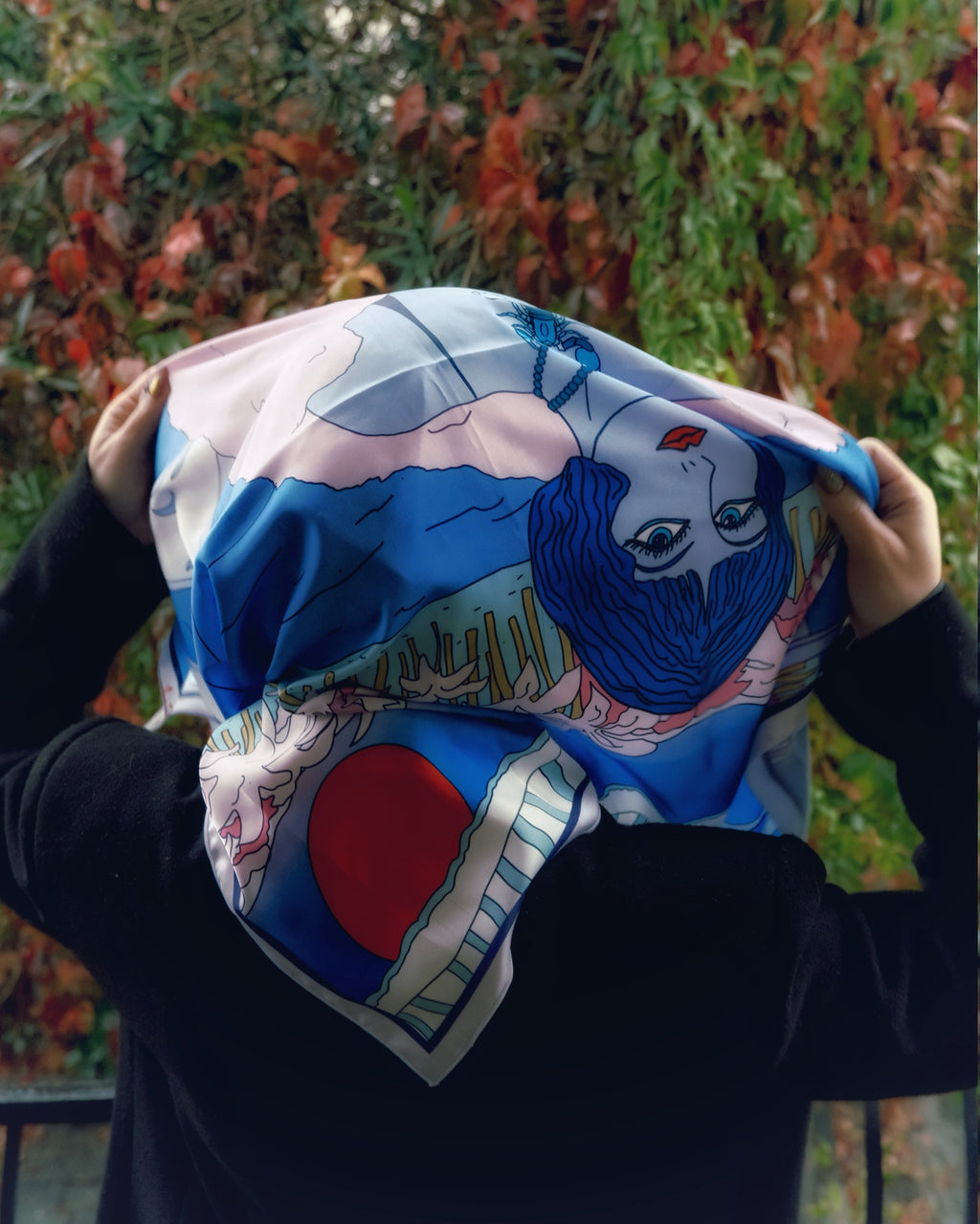 Model wearing the Scorpio zodiac silk scarf tied across shoulders, featuring bold purple and blue illustration