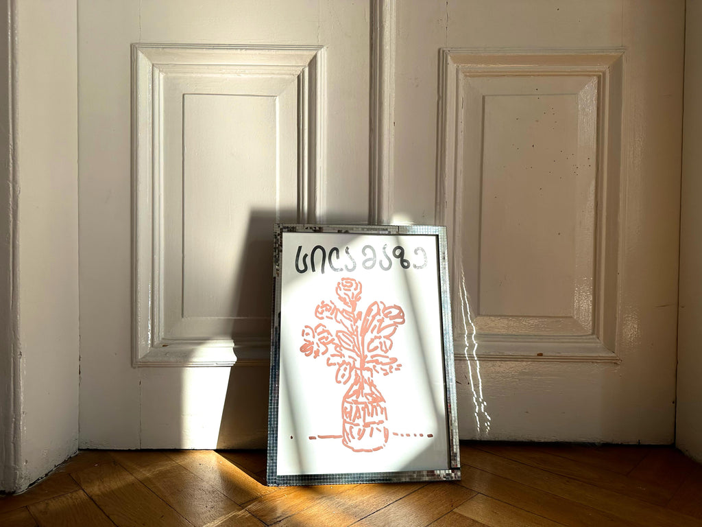 A poster with a red floral illustration leaning against a door, showcasing clean lines and refined details.