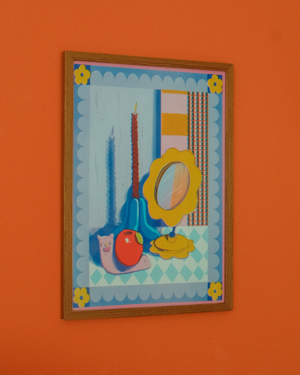 Framed artwork with colorful objects on an orange wall