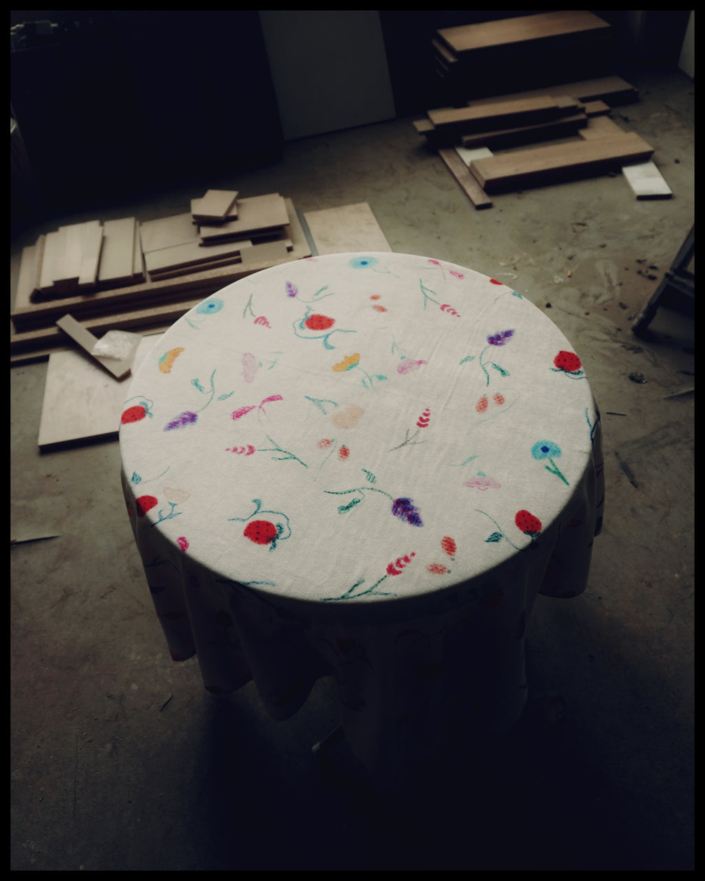 A tablecloth with a floral pattern, featuring colors such as green, pink, and yellow, displayed on a table with a sublimation print method.