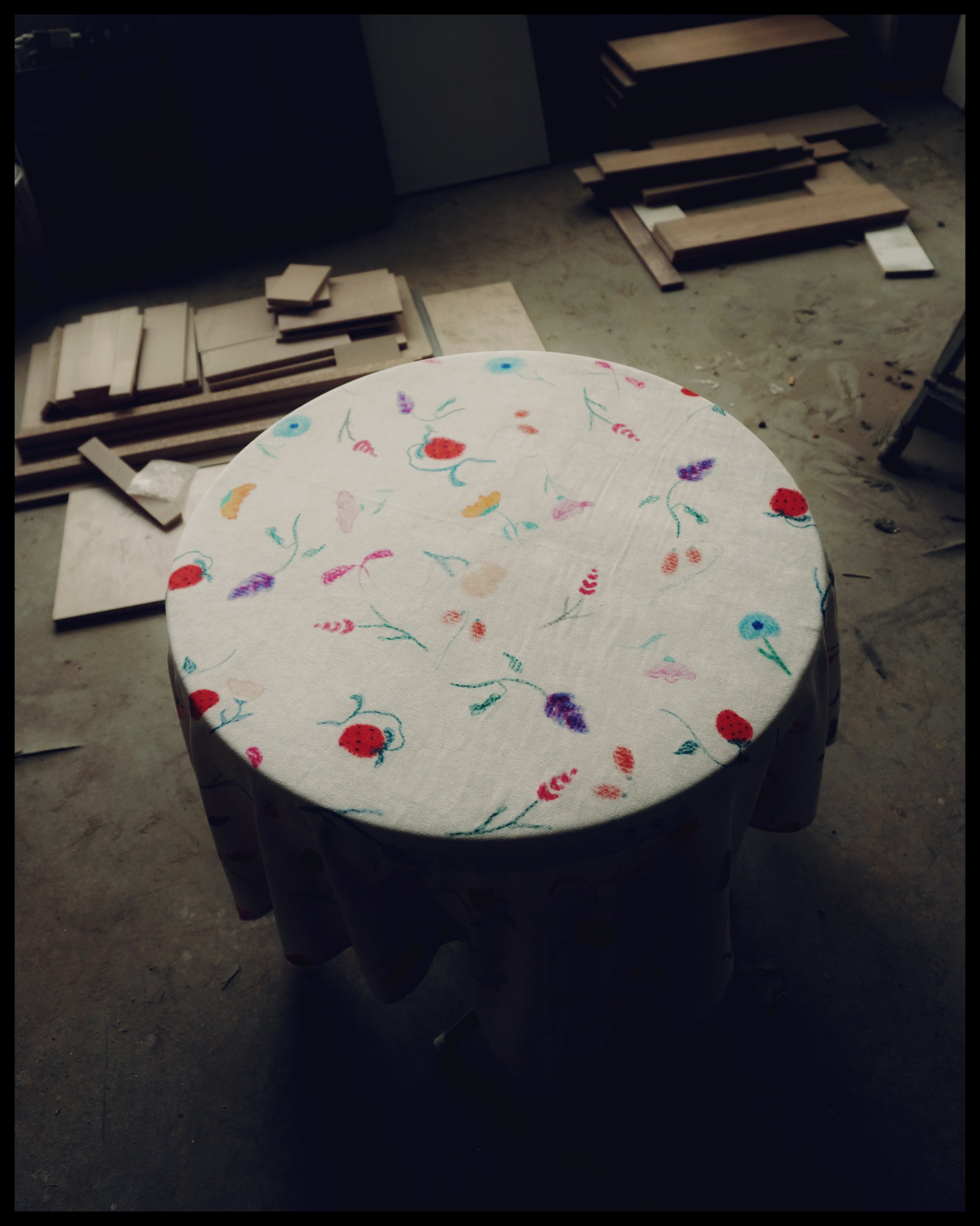 A tablecloth with a floral pattern, featuring colors such as green, pink, and yellow, displayed on a table with a sublimation print method.