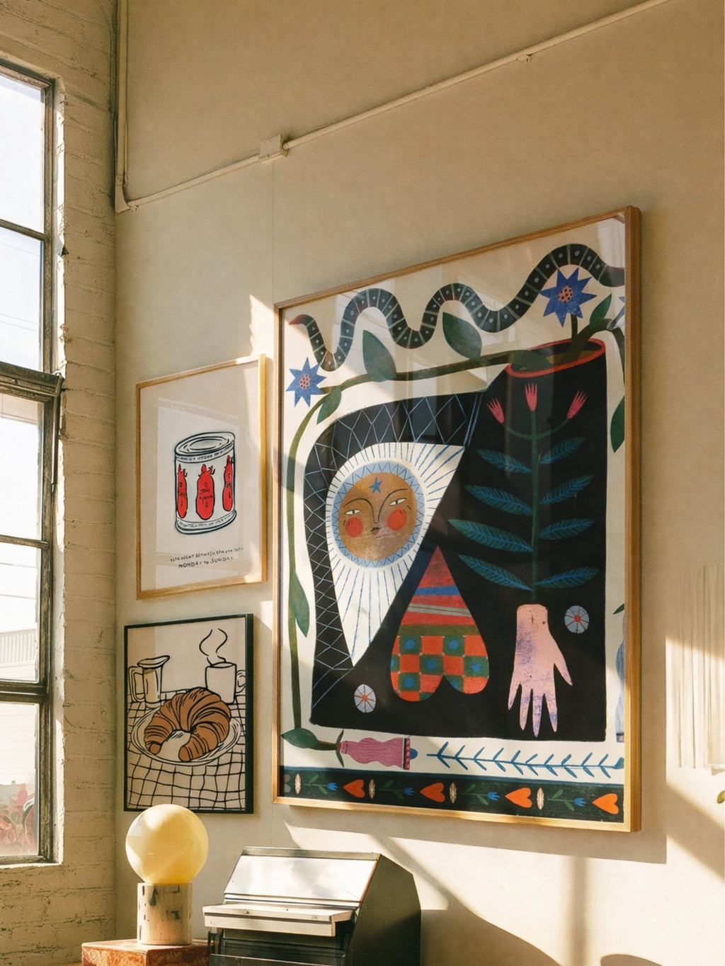 Artistic wall decor with abstract painting and framed prints on a light-colored wall.