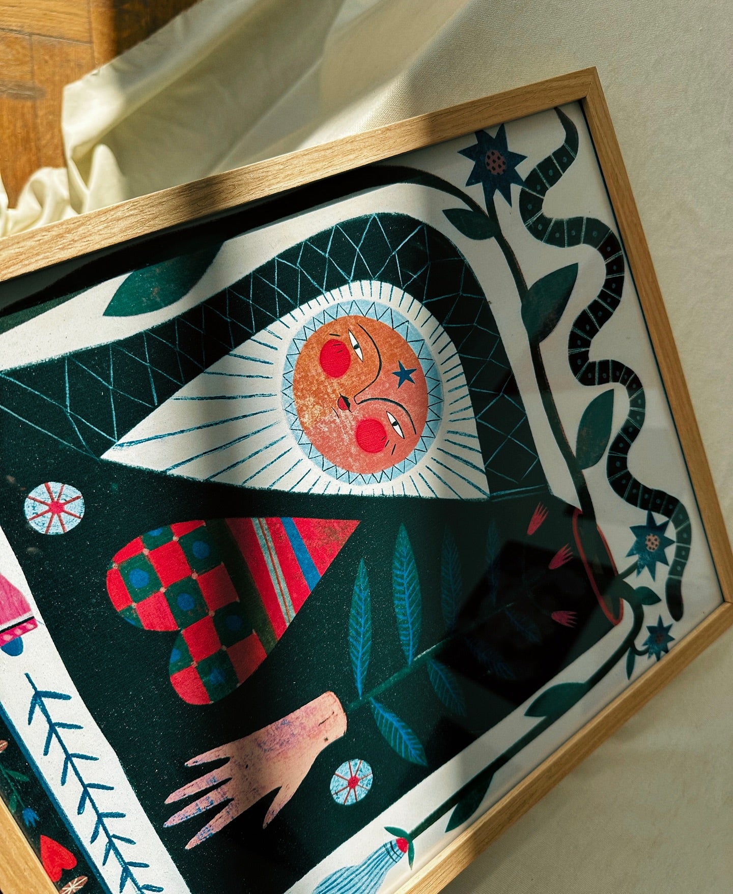 poster with different figures, sun, snake, flowers, plants, on the table