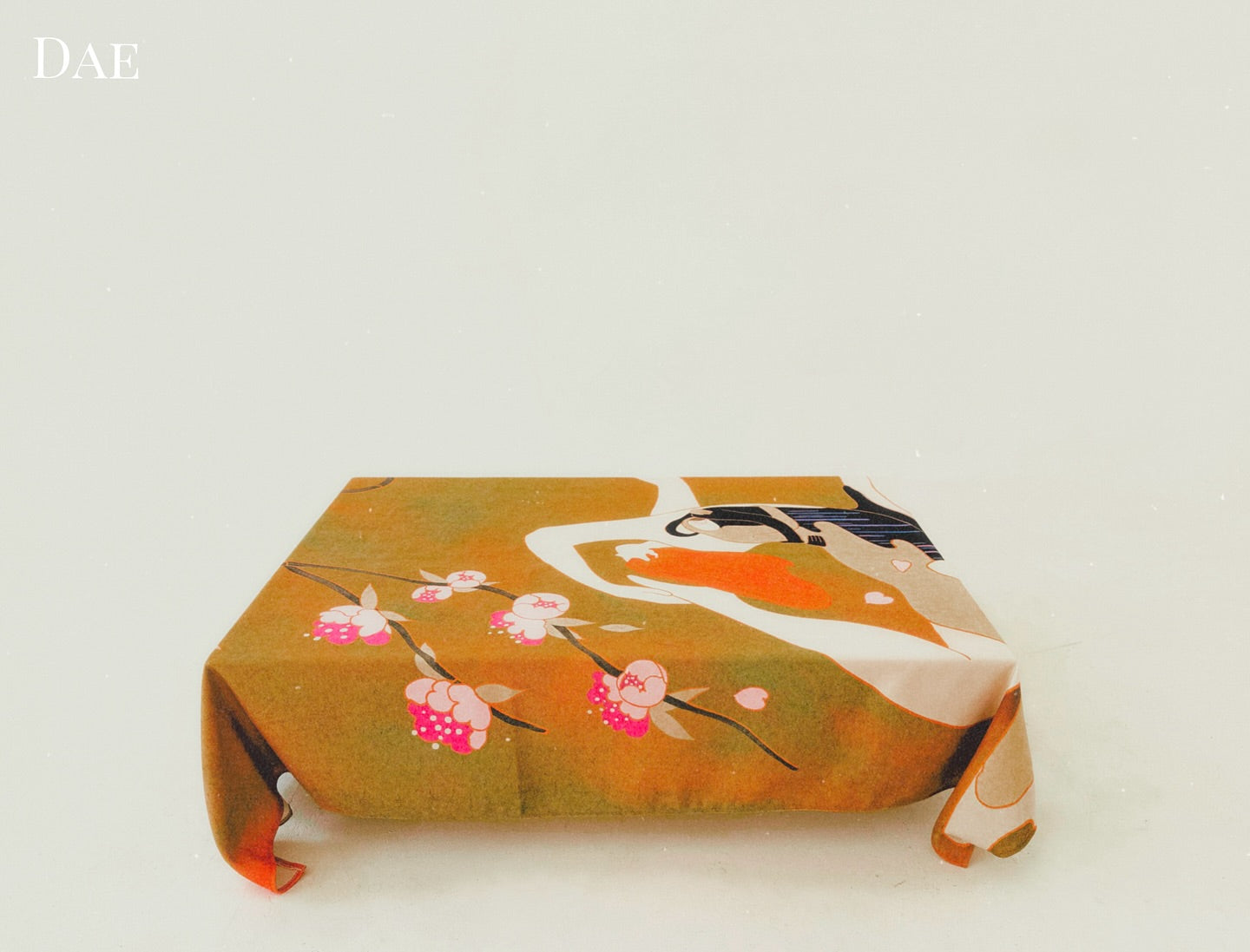 A tablecloth with an illustration of a woman in a yoga pose, with alternative silhouettes and blossoming flowers, symbolizing self-discovery and inner balance.