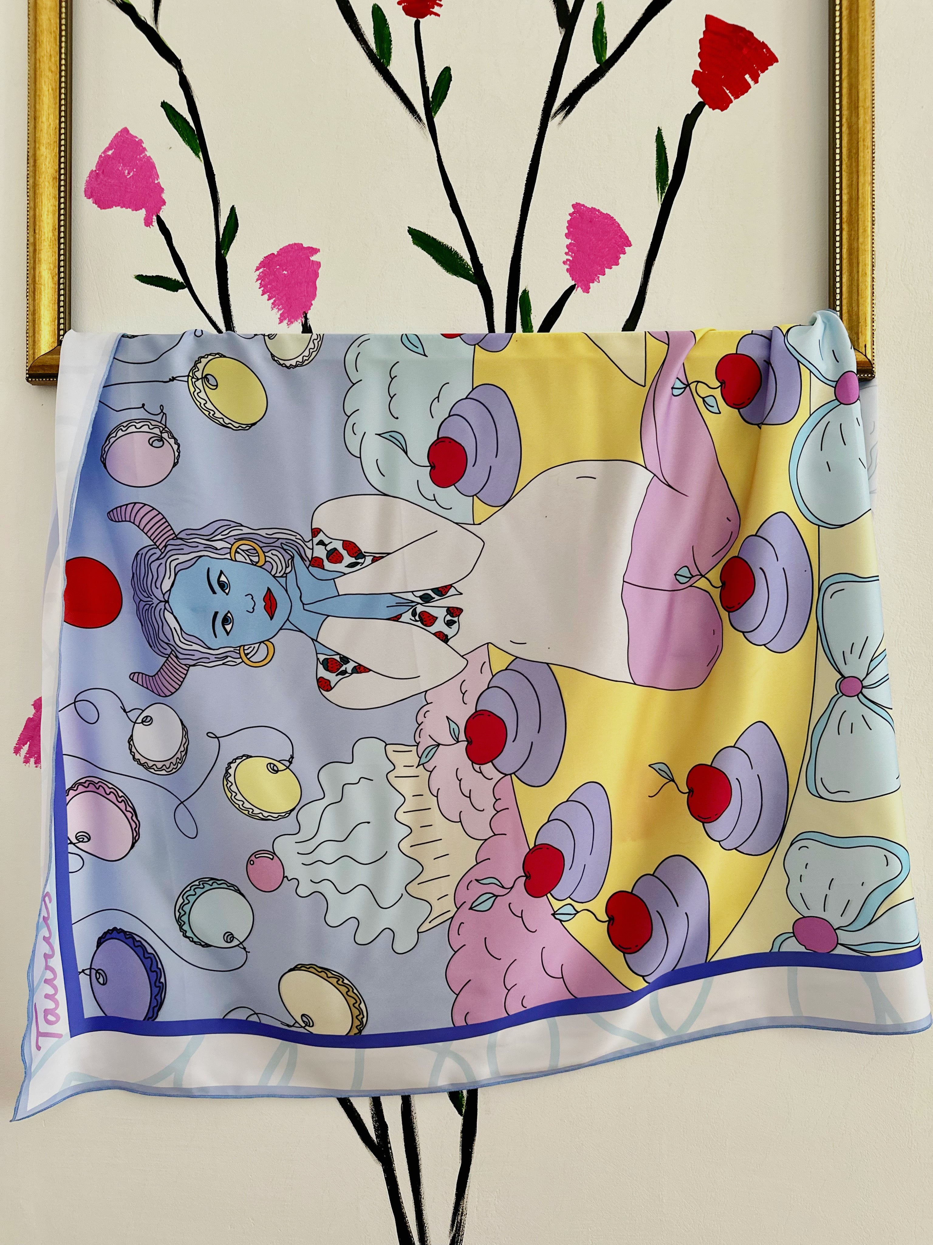 Taurus zodiac scarf with pastel colors and symbolic earthy elements, hanging on the frame