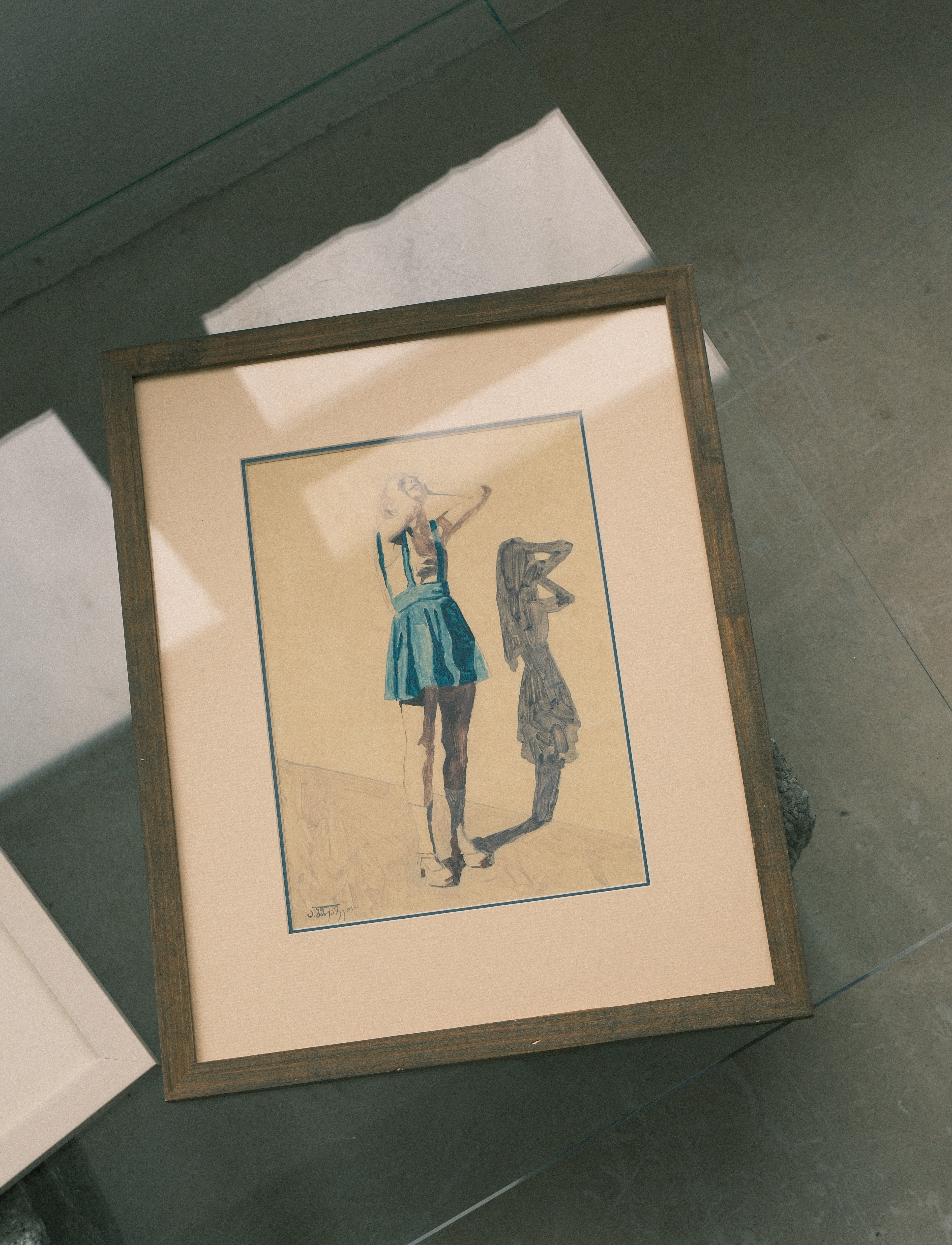 Framed artwork of a woman in a blue dress on a textured surface